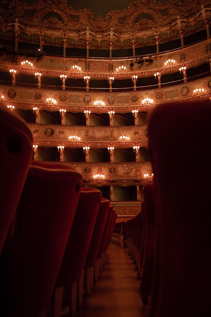 Opera House in Italy with lights, seating and red chairs in a theatre